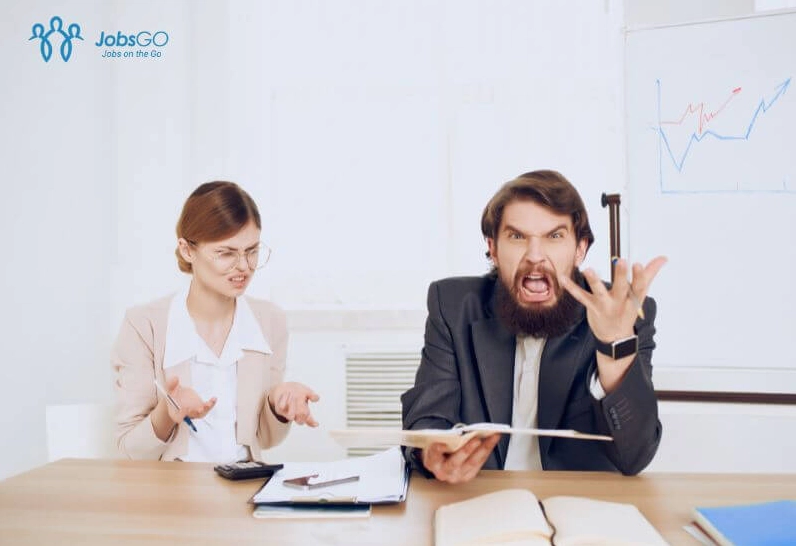 Hình ảnh minh họa sự bất mãn trong môi trường làm việc với nhiều giấy tờ và biểu đồ