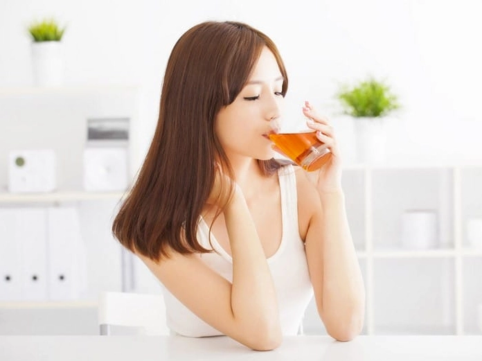 Ly trà thảo mộc ấm áp trên bàn