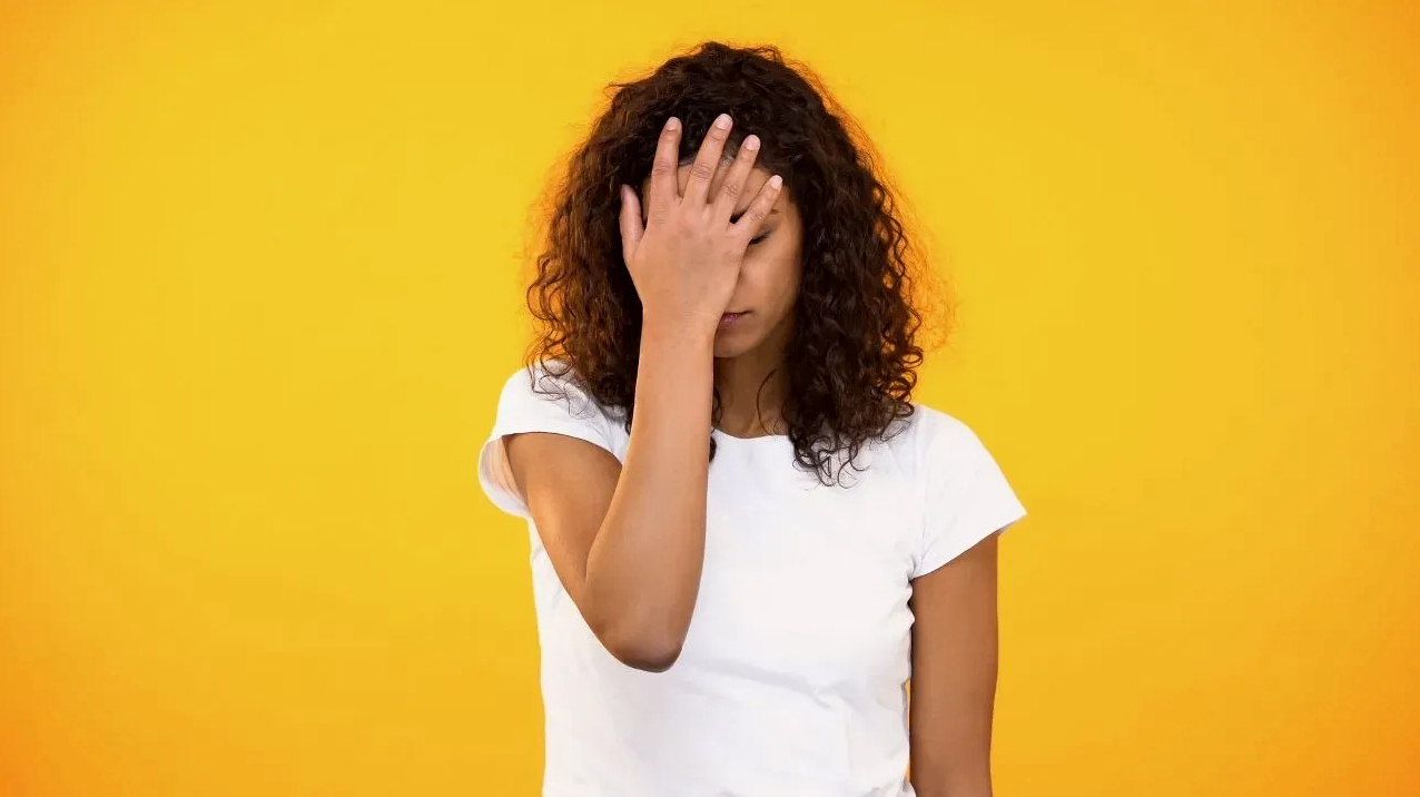 Người phụ nữ trẻ tỏ vẻ bất mãn khi nhìn vào màn hình điện thoại